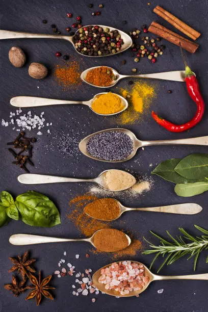 mix of colorful spices and aromatic herbs on a slate stone
