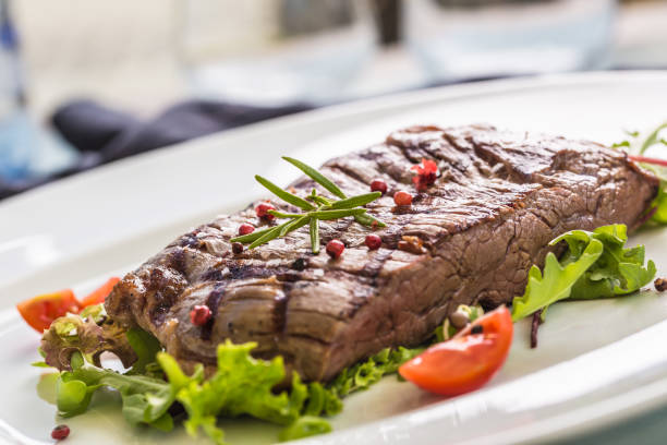 close-up teil saftige flanke steak vom salat salz pfeffer und rosmarin auf weißen teller. - skirt steak steak close up grilled stock-fotos und bilder