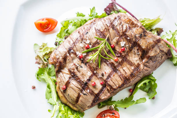 close-up teil saftige flanke steak vom salat salz pfeffer und rosmarin auf weißen teller. - skirt steak steak close up grilled stock-fotos und bilder