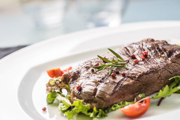 close-up teil saftige flanke steak vom salat salz pfeffer und rosmarin auf weißen teller. - skirt steak steak close up grilled stock-fotos und bilder