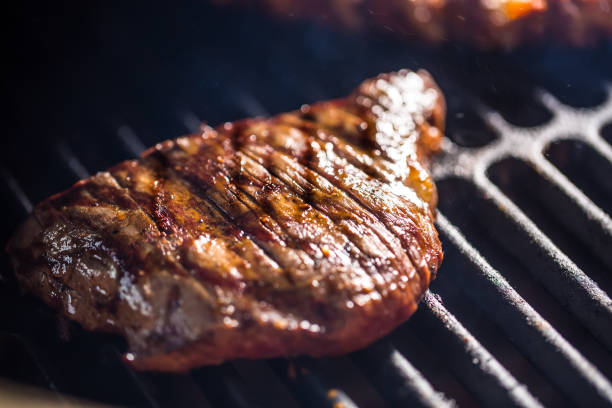 istock Close-up Beef flank steak cooking on grill. 1029248300