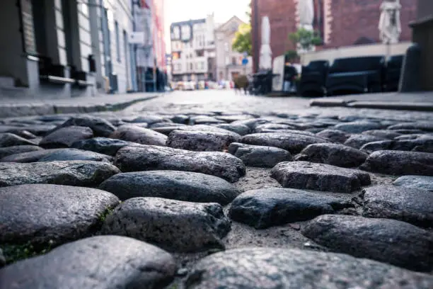 The texture of a stone pavement in the rays of the morning sun. Cobblestone pavement in the historic center of Riga, Latvia.