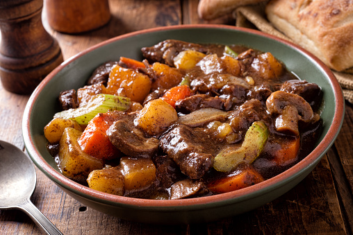 A bowl of delcious hearty homemade beef stew with potato, turnip, carrot, celery, mushroom and onion.