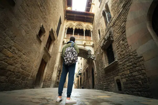 Photo of Travel man stand Bridge between buildings in Barri Gotic quarter of Barcelona