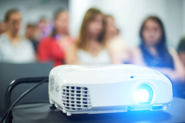 istock Close-up multimedia projector with blurred people background. 1029259132