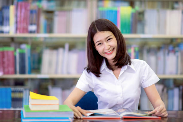 istock Asian lady student smile and do homework in libraly in university 1029262216