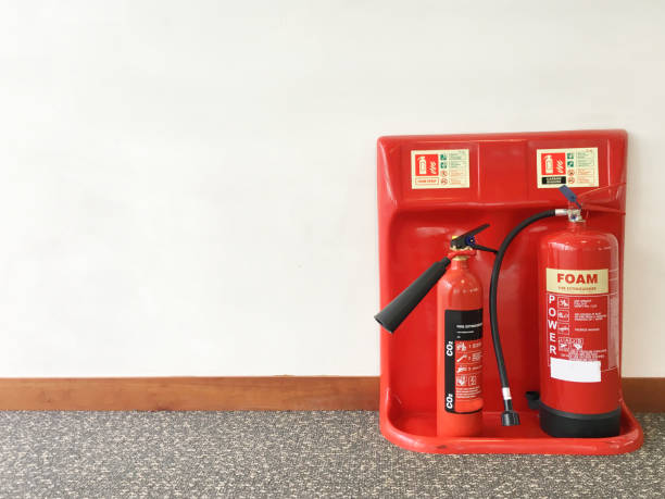 extintor de incendios en la oficina de trabajo contra el fondo neutro - fire extinguisher office safety protection fotografías e imágenes de stock