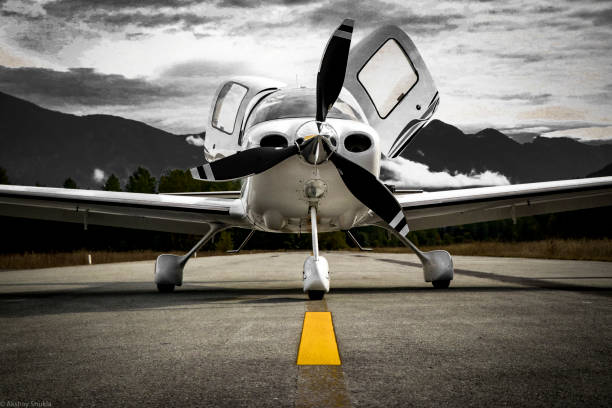 Low Wing Airplane Low wing airplane on the ​taxiway in the mountainous region of British Columbia. airplane hangar photos stock pictures, royalty-free photos & images