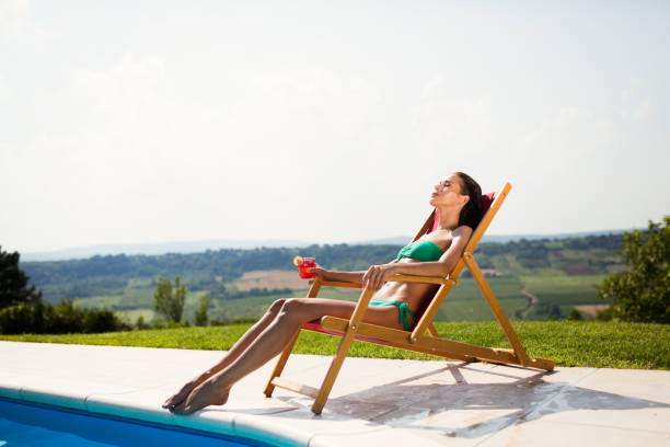 istock Sunbathing woman enjoying cocktail 1029272324
