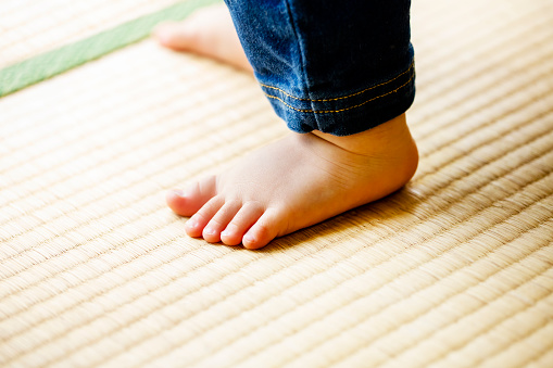 Child walking on tatami in japanese house.child foot.close up.
