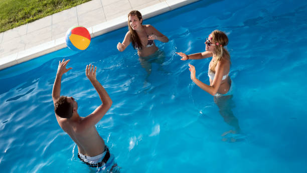 friends playing ball games in pool - volleying sport summer men imagens e fotografias de stock