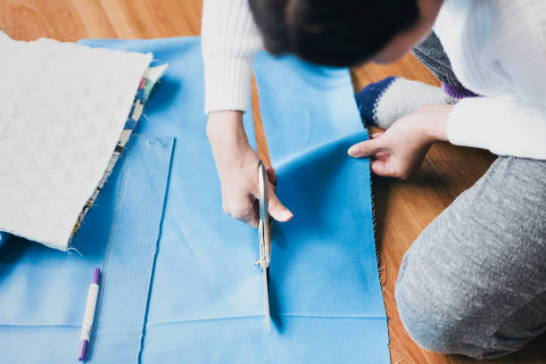 istock Woman cutting cloth with scissors 1029279150