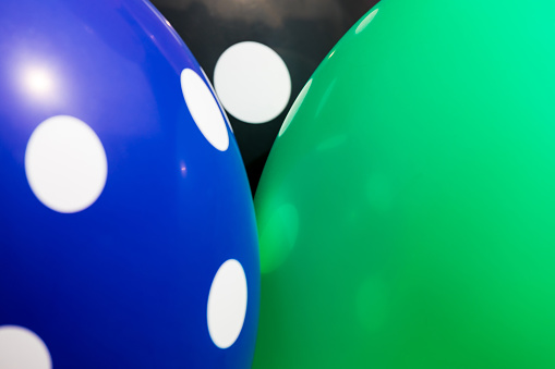 Background of blue, green and black balloons with the white circles on them. The optimistic picture, the symbol of happiness and joy
