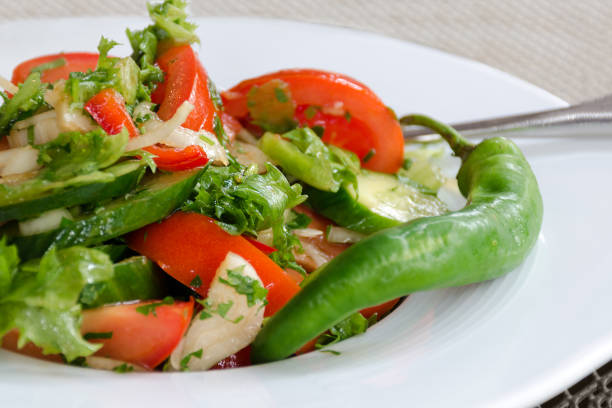 istock fresh salad with vegetables in plate - cucumbers, tomato, greens 1029290624