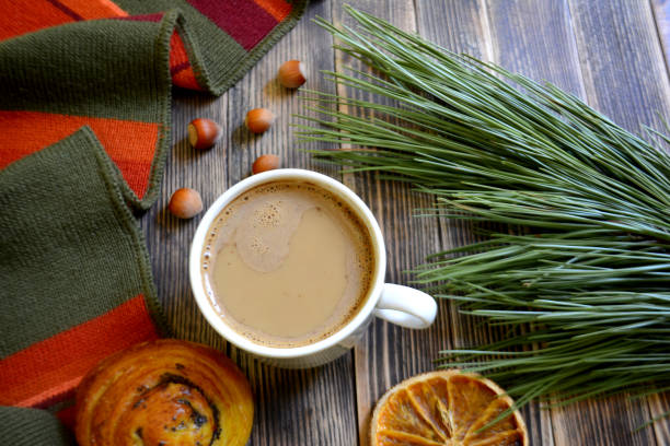 istock coffee cup in hand branch Christmas tree book on wooden background 1029292836