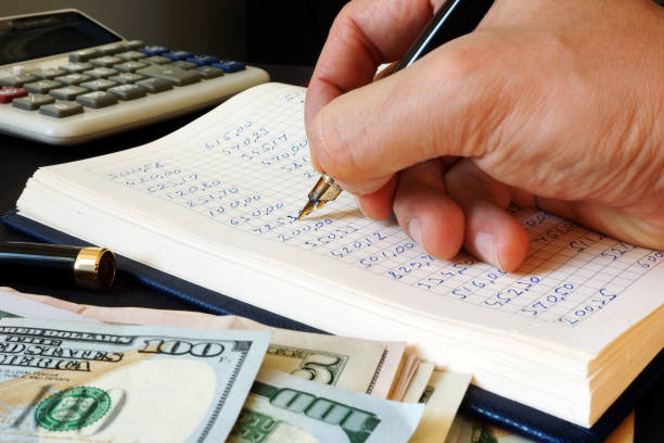istock Bookkeeper writing financial report into the bookkeeping book. 1029297668