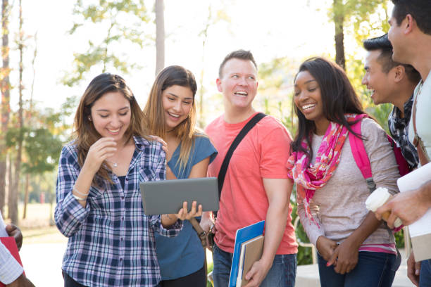 istock College student friends share digital tablet on university campus. 1029310734