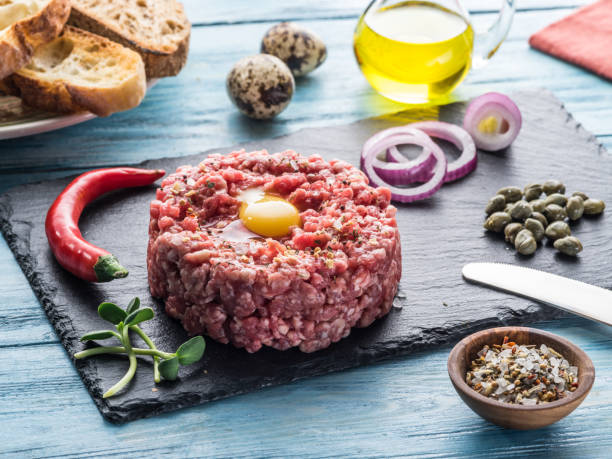 istock Steak tartare served with raw quail egg yolk, capers and bread. 1029310832