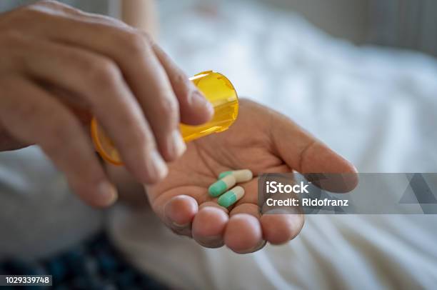 Medicina De Toma De Mano De Hombre Foto de stock y más banco de imágenes de Medicamento - Medicamento, Antibiótico, Antidepresivo