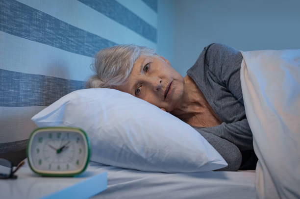 Insomnia at night Worried senior woman in bed at night suffering from insomnia. Old woman lying in bed with open eyes. Mature woman unable to sleep at home. sleep disorder stock pictures, royalty-free photos & images