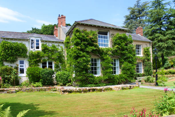 Netherbury, Dorset, UK - July 02, 2018: Large country house with climbing wisteria and roses. This type of real estate is much sought after in rural England.
