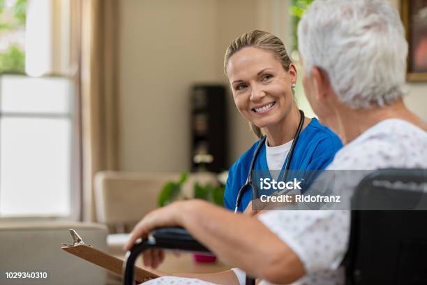 Friendly Nurse Talking To Senior Patient Stock Photo - Download Image Now - Nurse, Patient, Senior Adult