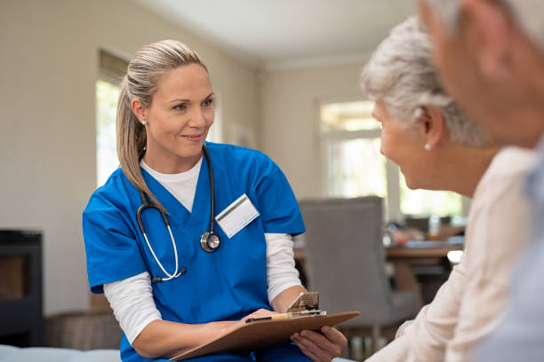 friendly nurse talking with old couple - female nurse imagens e fotografias de stock