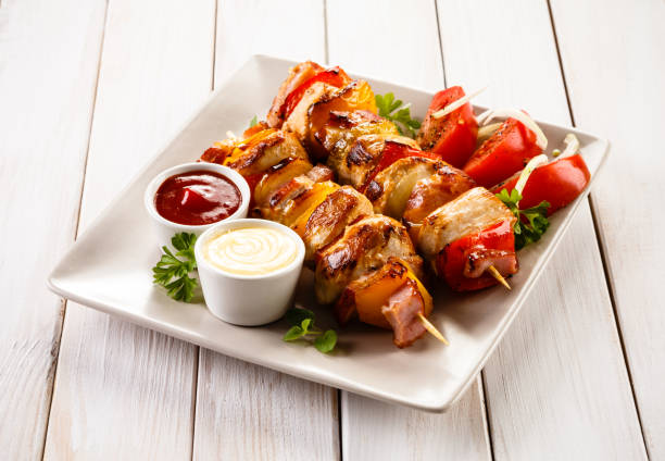 istock Kebabs - grilled meat and vegetables on wooden background 1029343244