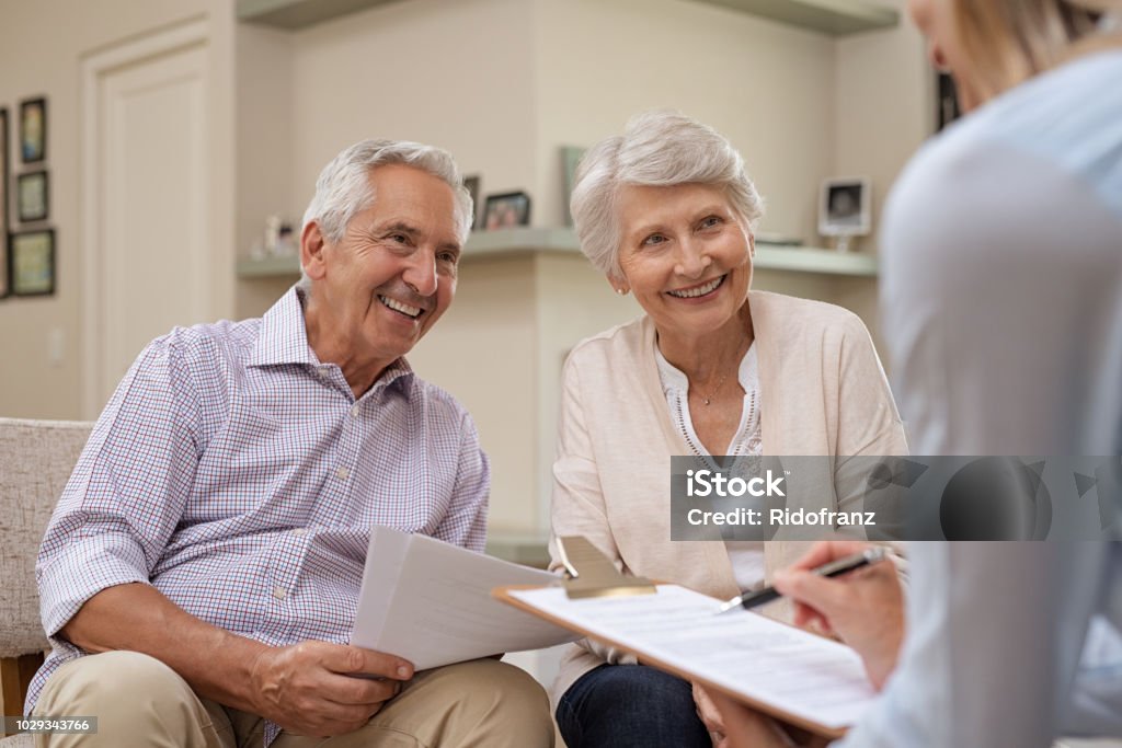Senior couple meeting financial advisor Senior couple meeting real estate agent at home. Old husband and wife with financial advisor for investment opportunities. Happy elderly man and woman listening to various investment plans for their retirement. Senior Adult Stock Photo