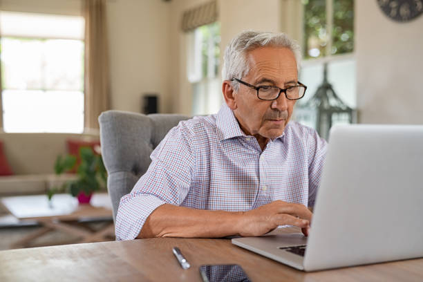 uomo anziano che usa il laptop - computer old men laptop foto e immagini stock