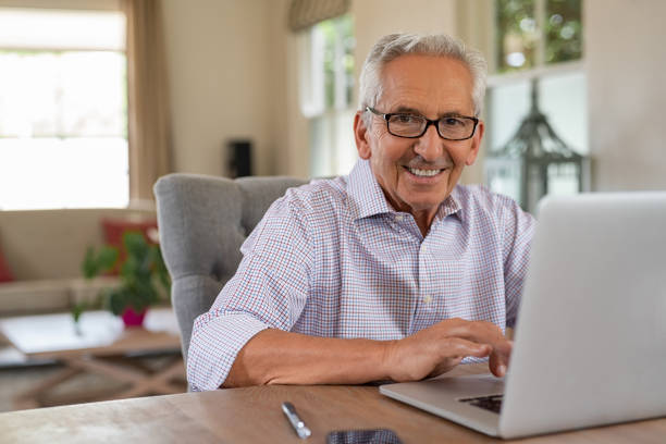 felice vecchio sorridente con laptop - telephone keypad old white foto e immagini stock