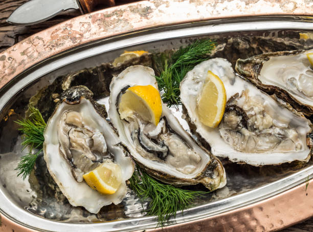 istock Opened oysters with piece of lemon. 1029351188