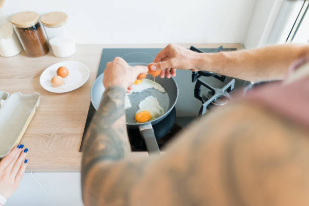 les œufs sont pour le petit déjeuner aujourd'hui - break eggs domestic kitchen breaking photos et images de collection