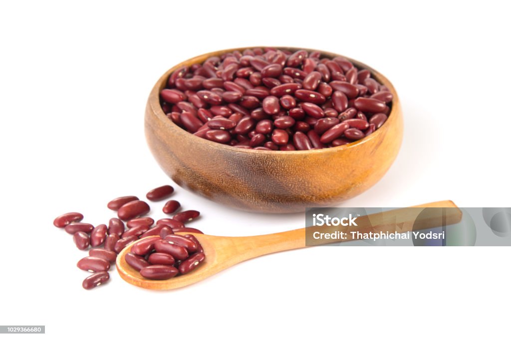 Red beans in wooden bowl and spoon isolated on white background Red beans in wooden bowl and spoon isolated on white background. Agriculture Stock Photo