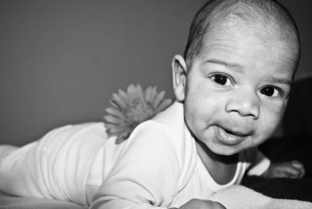 Black and white studio photo from the 60s, little baby girl posing looking away
