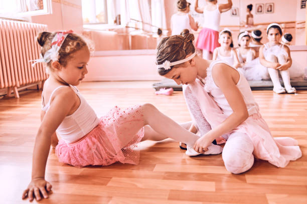 istock ballerinas helping each other tying the ballet shoes 1029386742