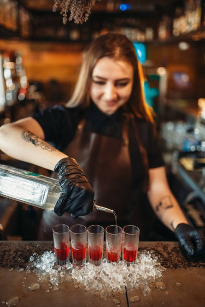 istock Female barman pours beverage into a glass 1029391288