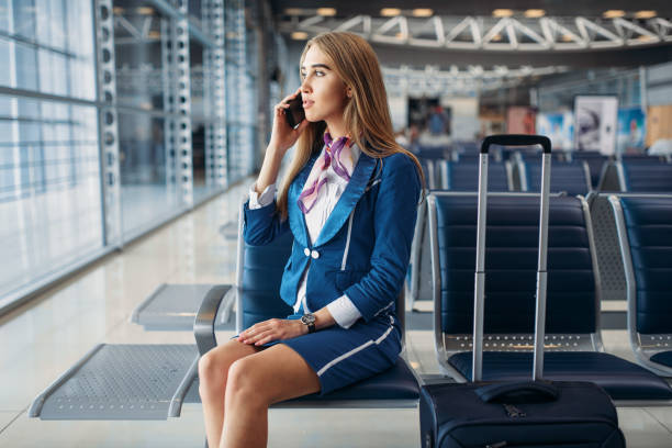 istock Stewardess talking by mobile phone in airport 1029396830