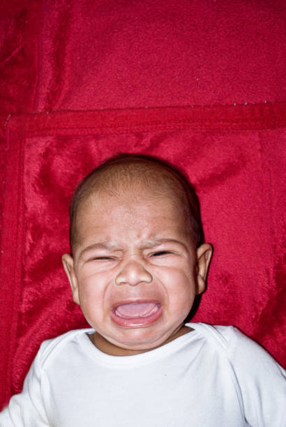 istock Unhappy Toddler On A Colourful Red Background Crying 1029400378