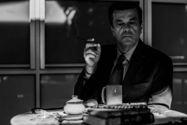 Man sitting at table with cigar having breakfast