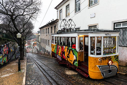 LISBON, circa 2017 - Ultra wide angle shot of Elevador da Gloria funicular tram streetcar, aka Ascensor da Gloria in Lisbon, Portugal pulling out. It connects Baixa with Bairro Alto.