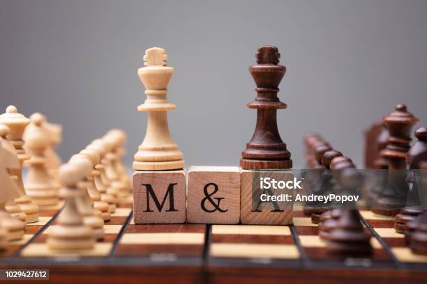 King Chess Pieces With Mergers And Acquisitions Text Stock Photo - Download Image Now