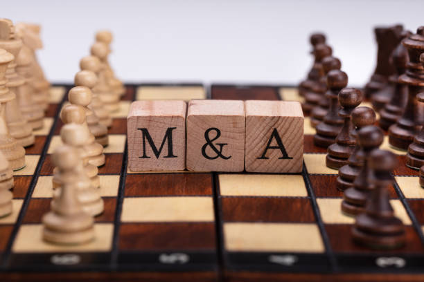 istock Wooden Blocks With Mergers And Acquisitions Text On Chess Board 1029427616