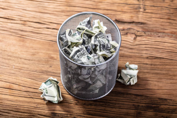 Bank Notes In Dustbin Elevated View Of Crumpled Bank Notes In Dustbin On Wooden Table throwing stock pictures, royalty-free photos & images