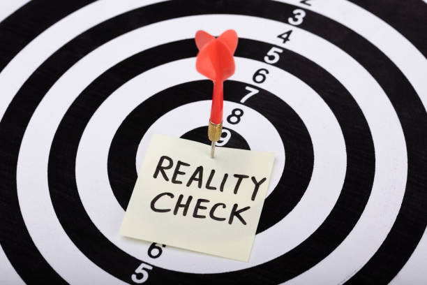 istock Dart And Arrow With Reality Check Word On Sticky Note 1029428282