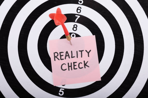 istock Dart And Arrow With Reality Check Word On Sticky Note 1029428294