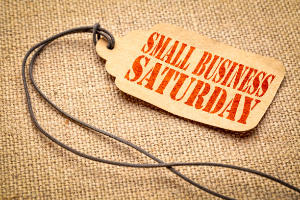 Small Business Saturday text on a price tag Small Business Saturday sign - a paper price tag with a twine iagainst burlap canvas small business saturday stock pictures, royalty-free photos & images