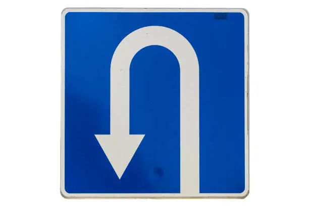 Photo of 'U-Turn' traffic road sign isolated on white.