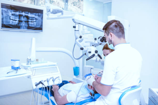 istock Two Dentists Fixing Patient's Teeth According To X-Ray Image 1029447048