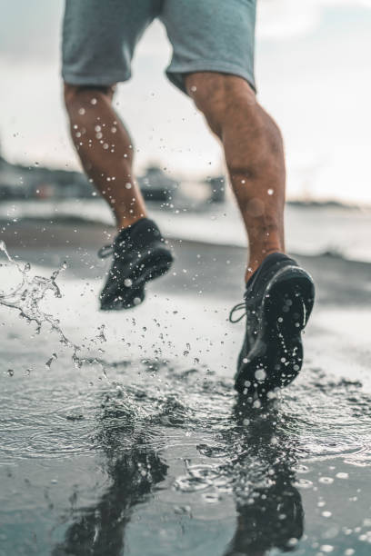 człowiek działa w deszczu - running jogging men shoe zdjęcia i obrazy z banku zdjęć